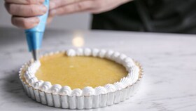 Tasaista marenkiseosta sitruunamarenkipiirakkaan annosteleva leipuri