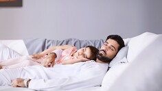 Lapsensa kanssa viileässä ja hiljaisessa kodissa nukkuva vanhempi
