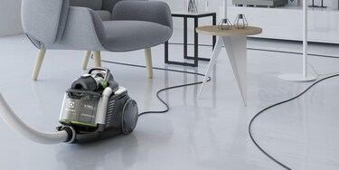 Erittäin pitkän virtajohdon avulla olohuonetta helposti puhdistava Electrolux UltraFlex Green -imurin käyttäjä