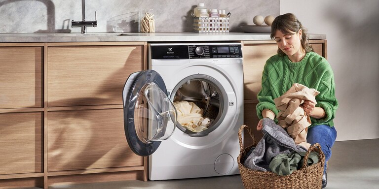 Nainen tyhjentää pesukonetta