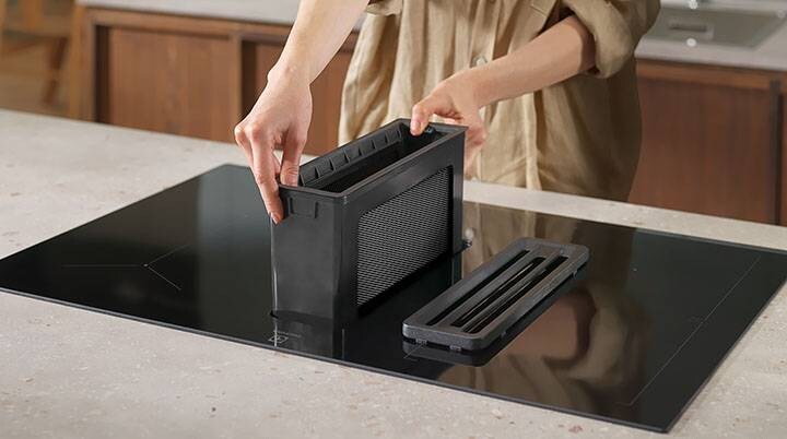 Kädet asettavat rasvasuodattimen takaisin induktiotasoliesituulettimeen