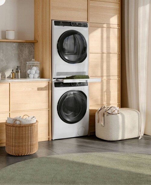 Electroluxin kuivausrumpu ja pesukone sijoitettuna päällekkäin aurinkoisessa huoneessa.  