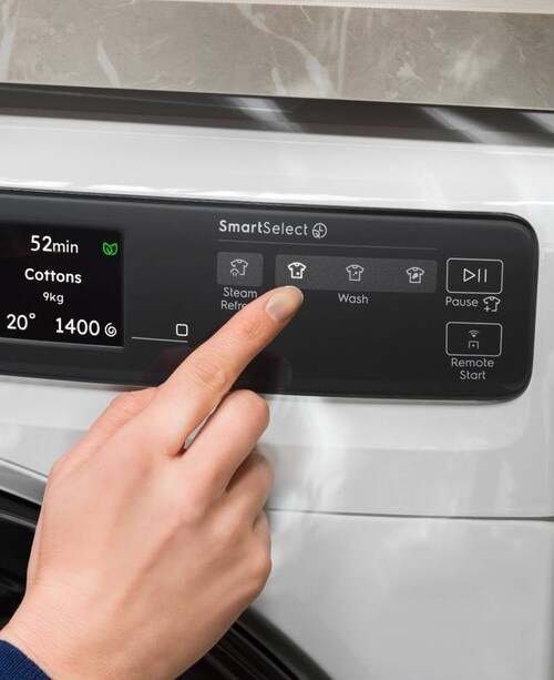 Henkilö säätää Electroluxin pesukoneen ohjauspaneelia.