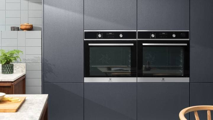 Kaksi kalusteisiin sijoitettua Electrolux-uunia tyylikkäässä keittiössä.