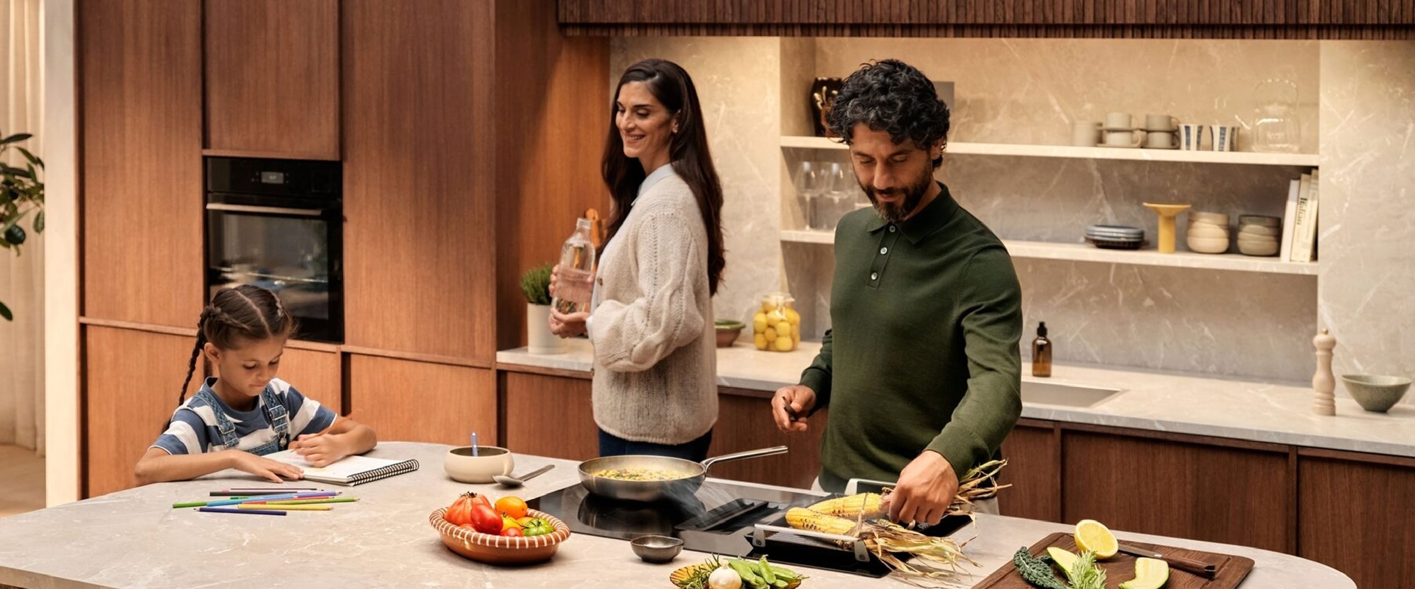 Mies, nainen ja pieni tyttö keittiössä.