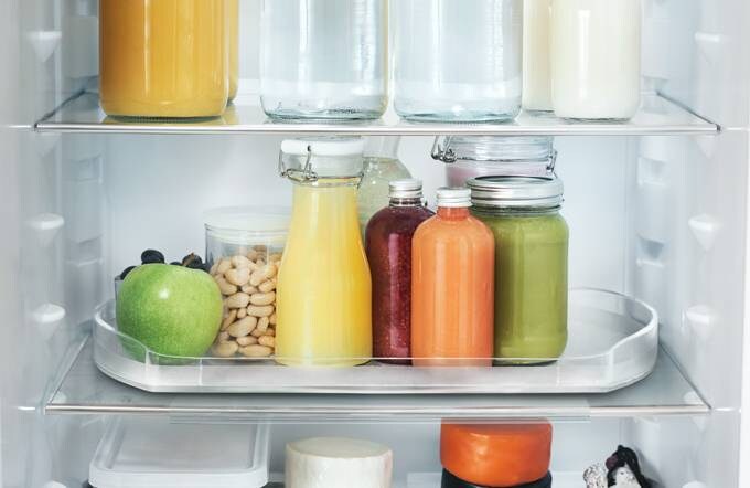 Tuoreita ruokatarvikkeita avonaisessa jääkaapissa. 