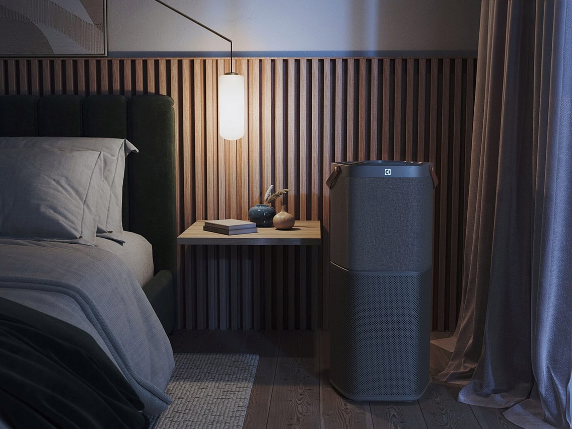 Electrolux-ilmanpuhdistin makuuhuoneessa, jossa on rimoitettu seinäpaneeli ja himmennetty valaistus.