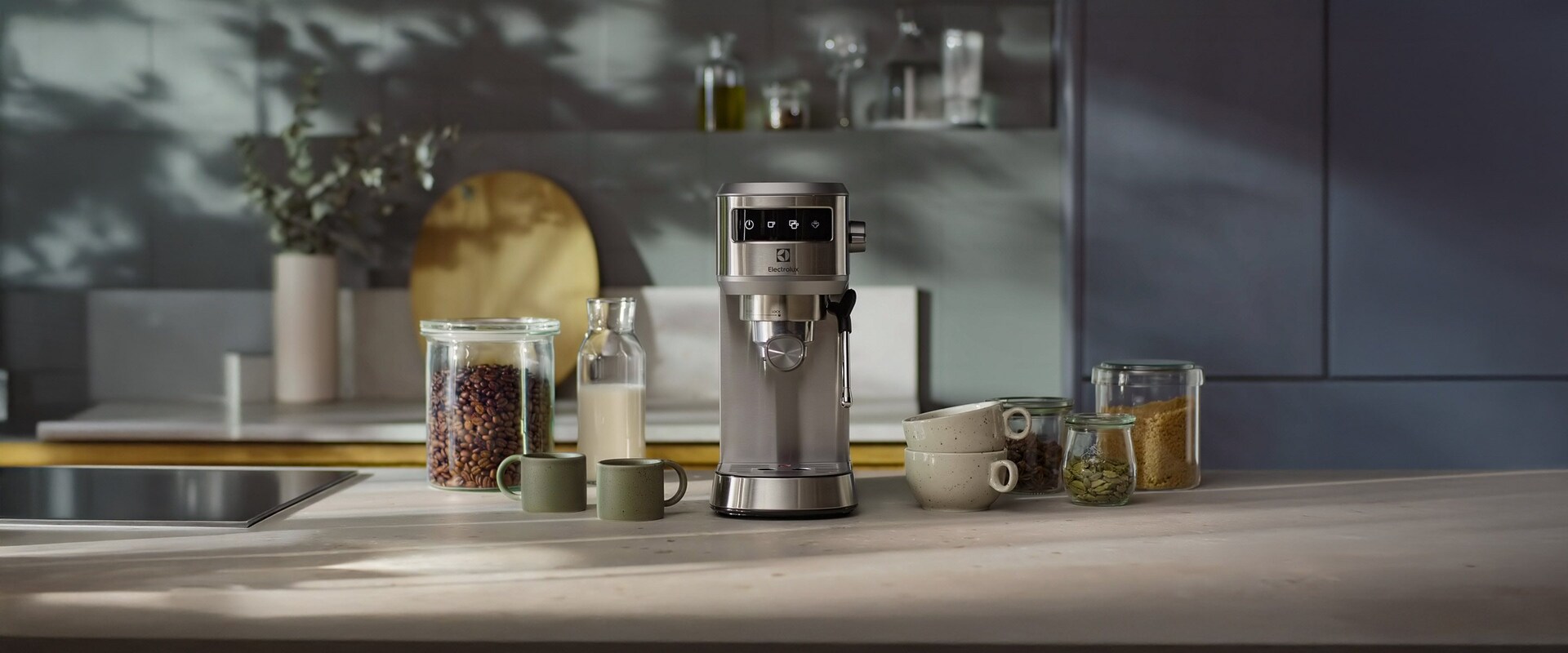 Hopeinen kahvinkeitin ja kahvinpapuja.