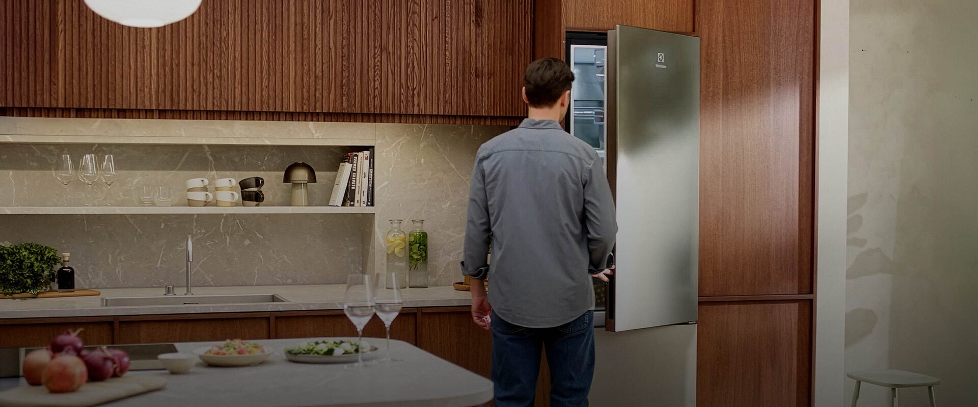 Mies avaa Electroluxin vapaasti sijoitettavan, ruostumattoman teräksen värisen jääkaappipakastimen