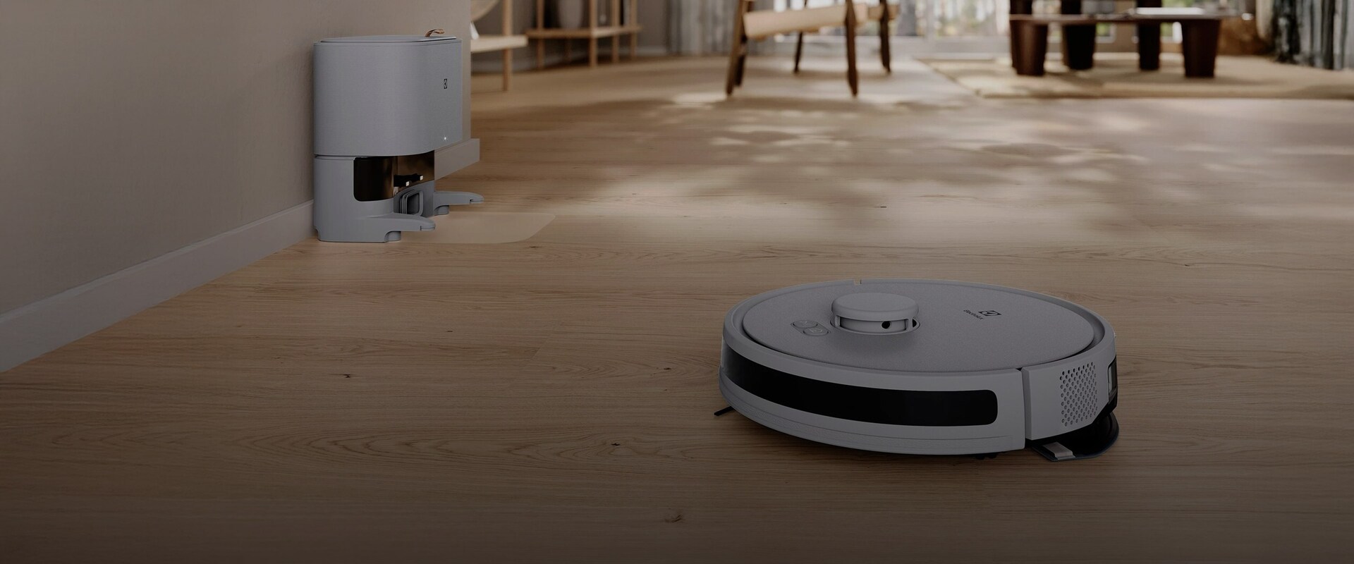 Itseohjautuva Electroluxin robotti-imuri puhdistaa vaaleaa puulattiaa avoimessa ja modernissa olohuoneessa.